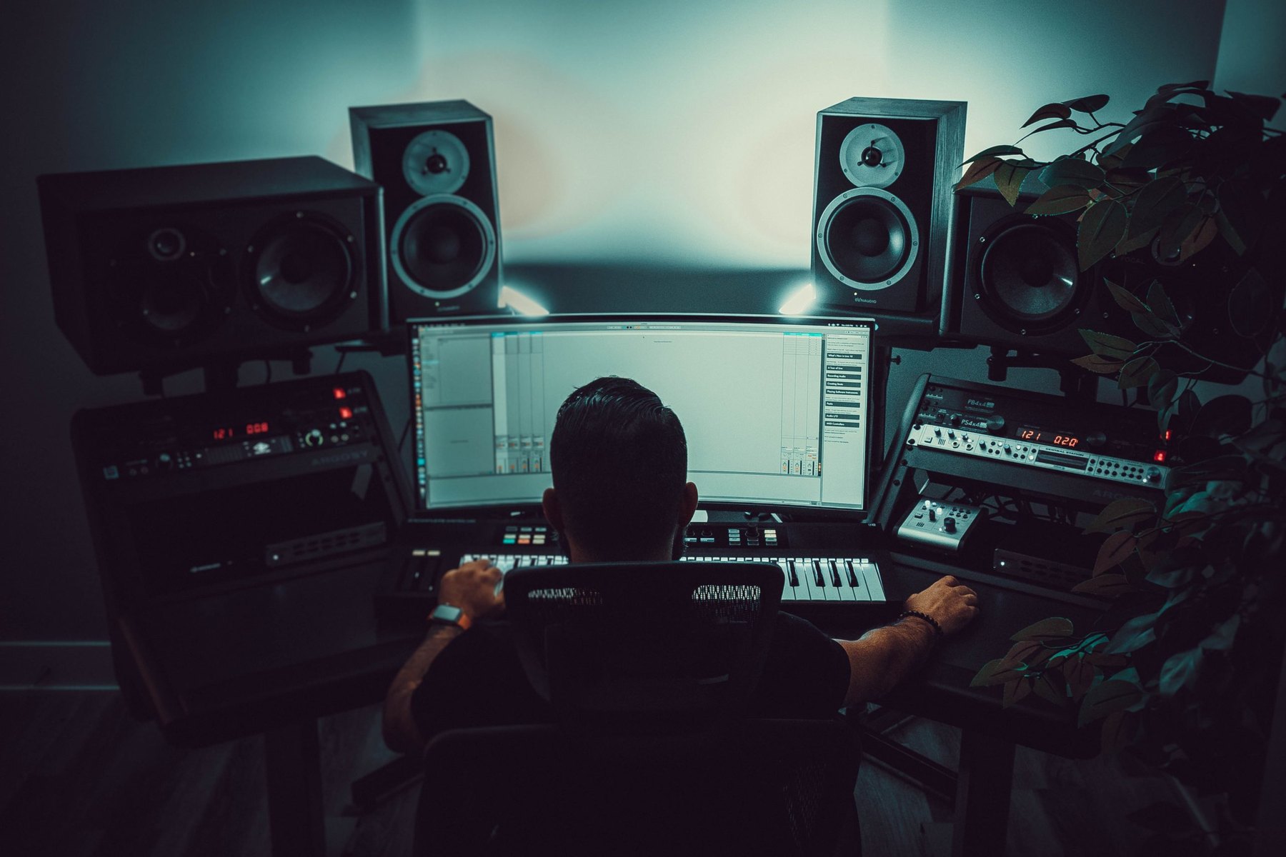Producer working in a studio with nearfield monitors and an open session on screen